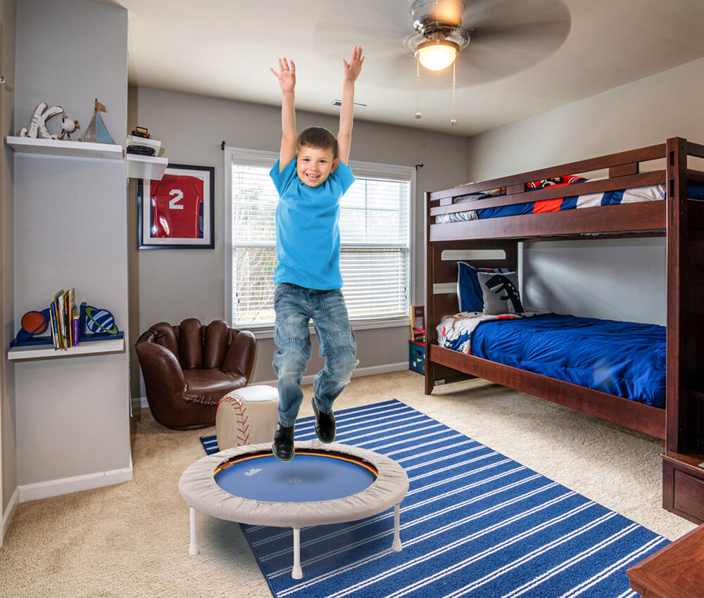 Junge springt im Kinderzimmer auf einem Trimilin-med Trampolin